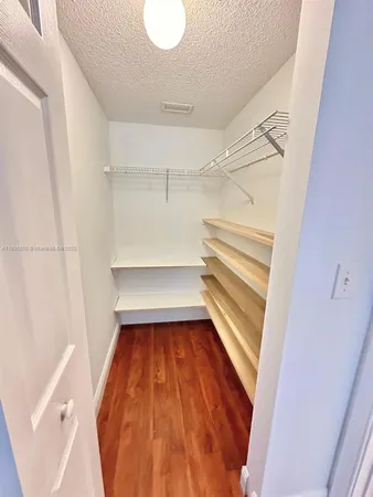 a view of a kitchen with kitchen island and stainless steel appliances