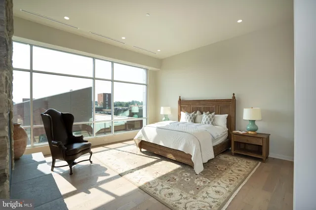 a bedroom with a bed and large windows