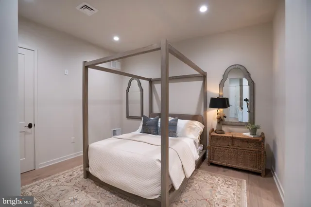 a bedroom with a bed a mirror and lamp