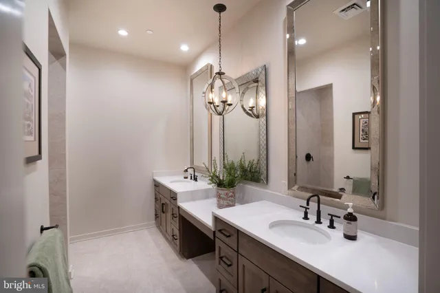 a bathroom with double vanity and a mirror