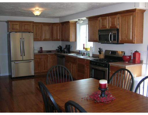 163 Prince Road Southbridge, MA 01550 - Photo 3 of 11 a kitchen with stainless steel appliances granite countertop a refrigerator a stove a sink a microwave dining table and chairs