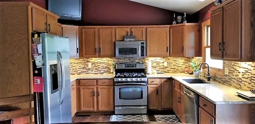 112 Pembroke Road Southwest Poplar Grove, IL 61065 - Photo 8 of 25 a kitchen with stainless steel appliances granite countertop a stove and a refrigerator
