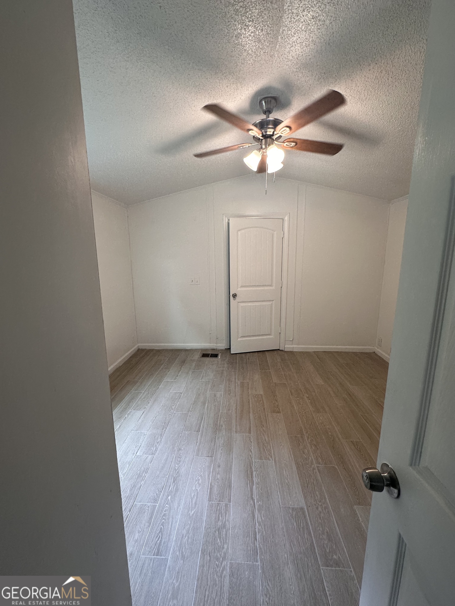 2023 Stephens Road Elberton, GA 30635 - Photo 14 of 21 an empty room with wooden floor fan and windows
