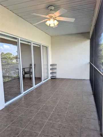 a view of a livingroom with a chandelier fan and windows