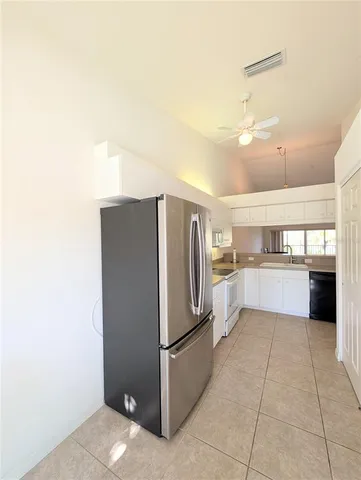 a kitchen with a refrigerator and white cabinets