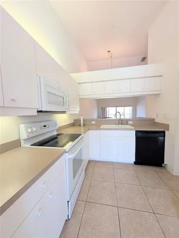 a large kitchen with stainless steel appliances granite countertop a stove a sink dishwasher and a refrigerator