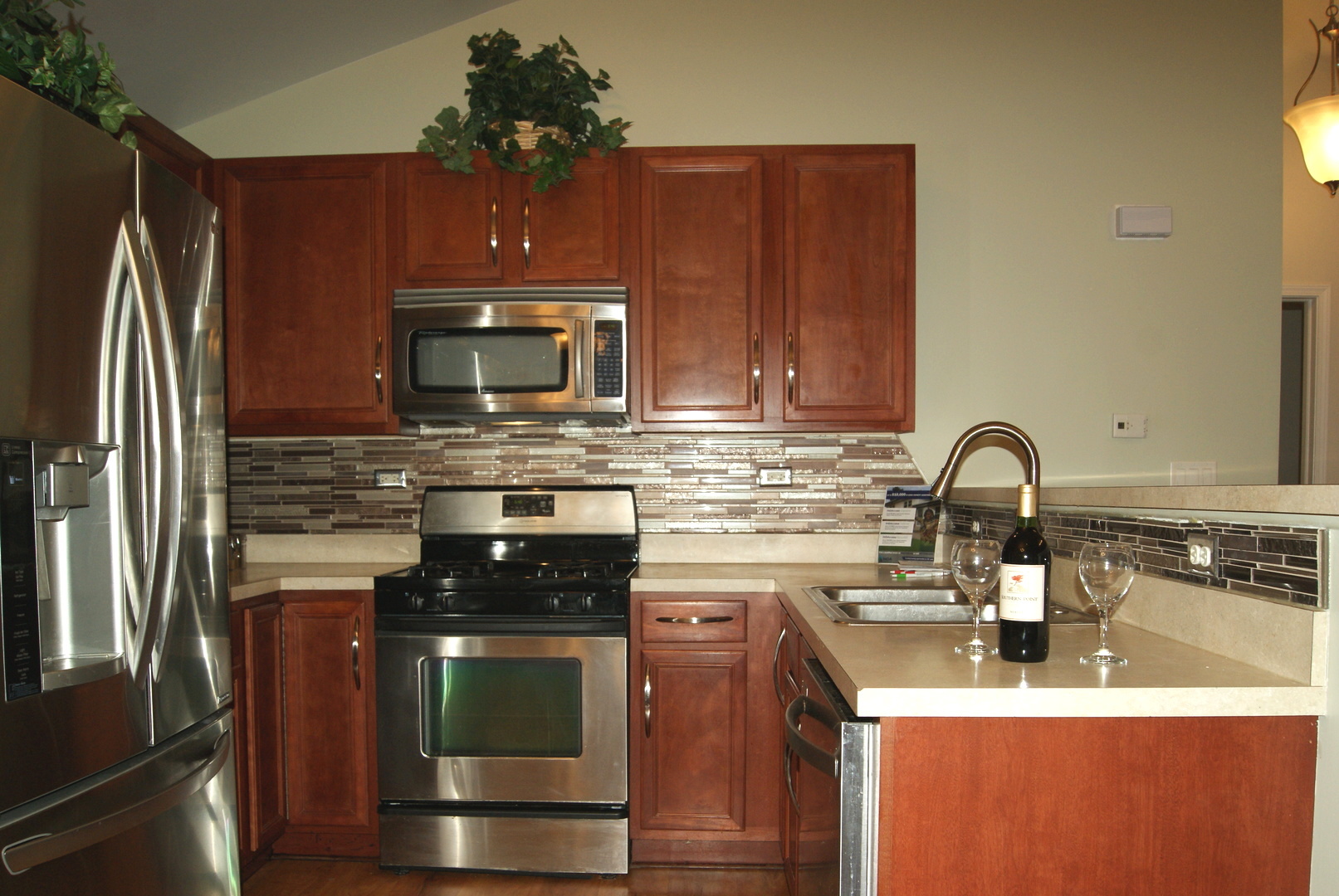 4425 Timber Ridge Court, Unit 4425 Joliet, IL 60431 - Photo 2 of 25 a kitchen with stainless steel appliances granite countertop a sink a stove and a refrigerator