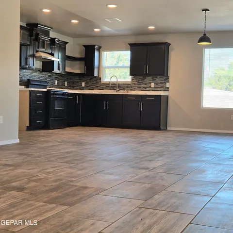 a large kitchen with stainless steel appliances granite countertop a stove sink and cabinets