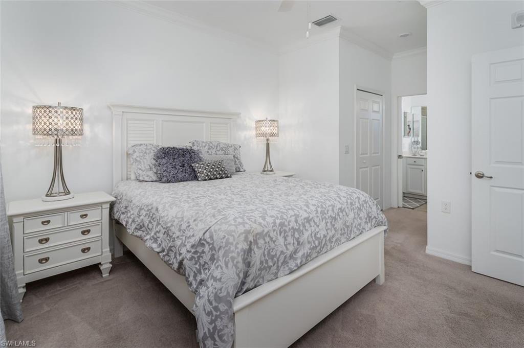 9596 Trevi Court, Unit 5431 Naples, FL 34113 - Photo 12 of 32 a bedroom with a bed and dresser