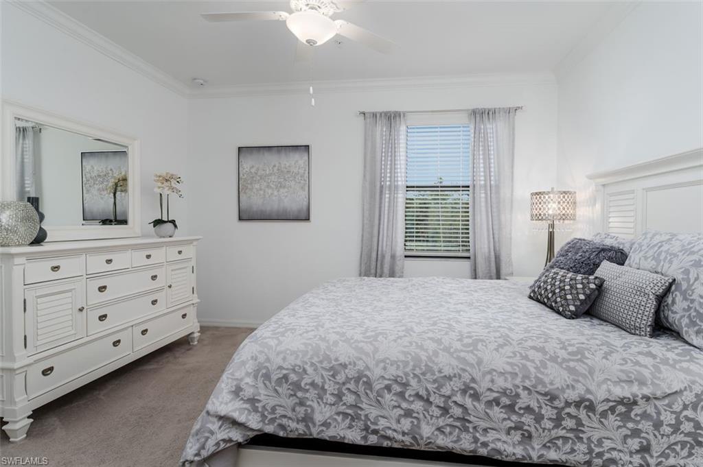 9596 Trevi Court, Unit 5431 Naples, FL 34113 - Photo 13 of 32 a bedroom with a bed and a dresser