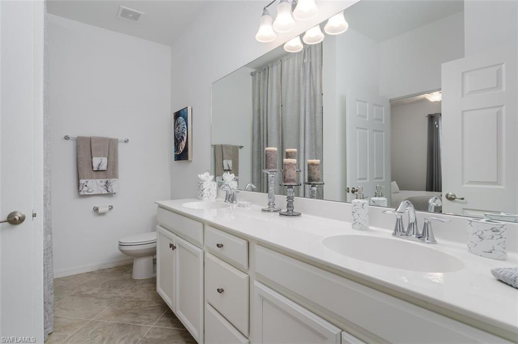 9596 Trevi Court, Unit 5431 Naples, FL 34113 - Photo 18 of 32 a bathroom with a double vanity sink mirror and toilet