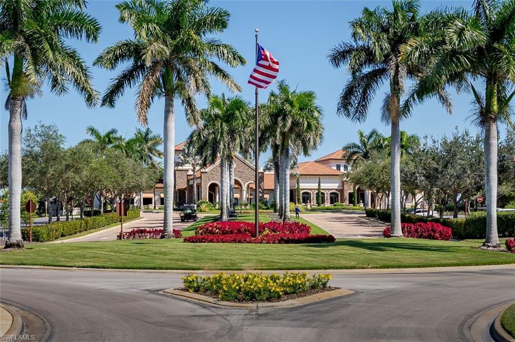 9596 Trevi Court, Unit 5431 Naples, FL 34113 - Photo 25 of 32 a front view of yellow house with small garden and trees
