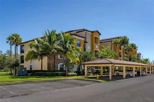 a view of a white house with a yard and potted plants