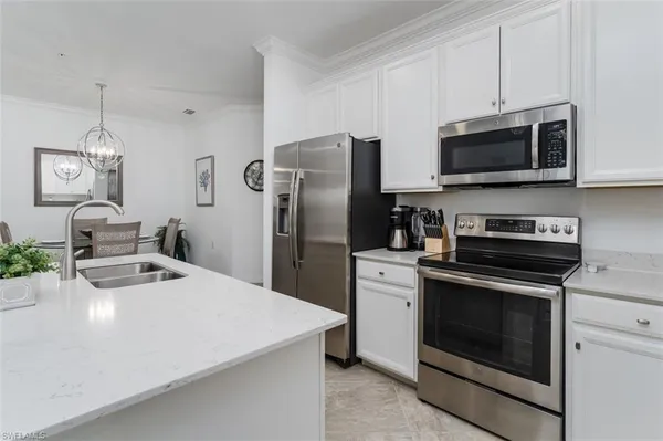 a kitchen with stainless steel appliances a stove a microwave and white cabinets