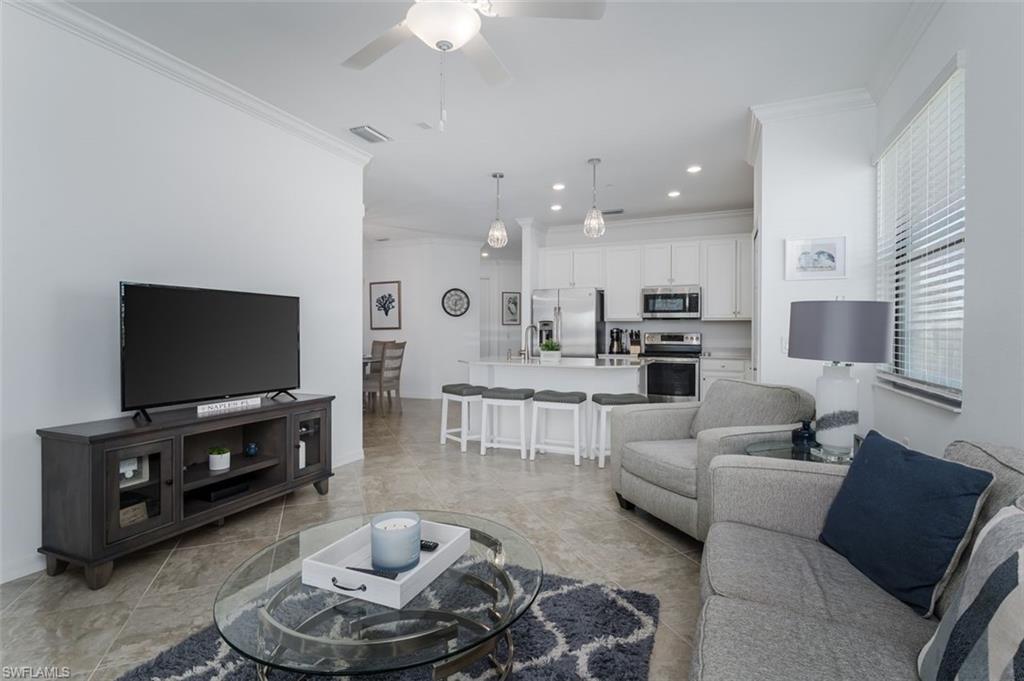 9596 Trevi Court, Unit 5431 Naples, FL 34113 - Photo 8 of 32 a living room with furniture and a flat screen tv