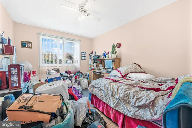 a bedroom with a large bed a chandelier and windows