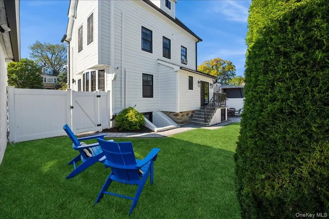 a view of a chair and table in backyard of the house