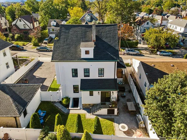 an aerial view of a house with swimming pool and large trees