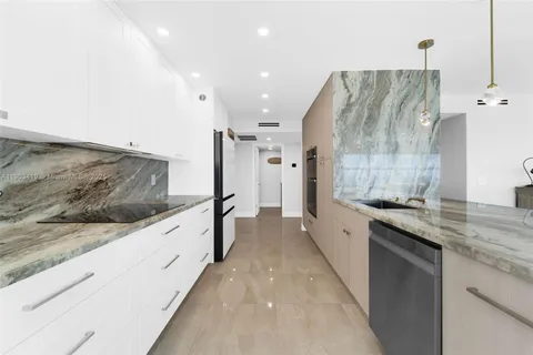 a large kitchen with stainless steel appliances kitchen island granite countertop a sink and cabinets