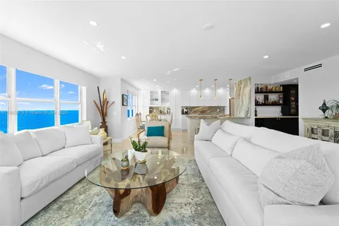 a living room with furniture and kitchen view