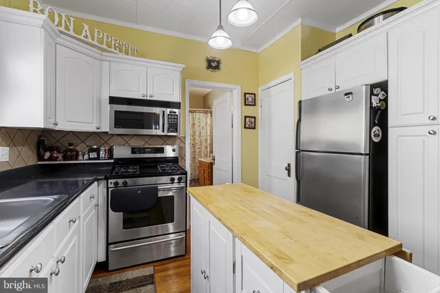 a kitchen with stainless steel appliances granite countertop a stove a refrigerator and a microwave