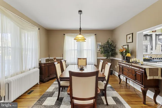 a dining room with furniture window and wooden floor