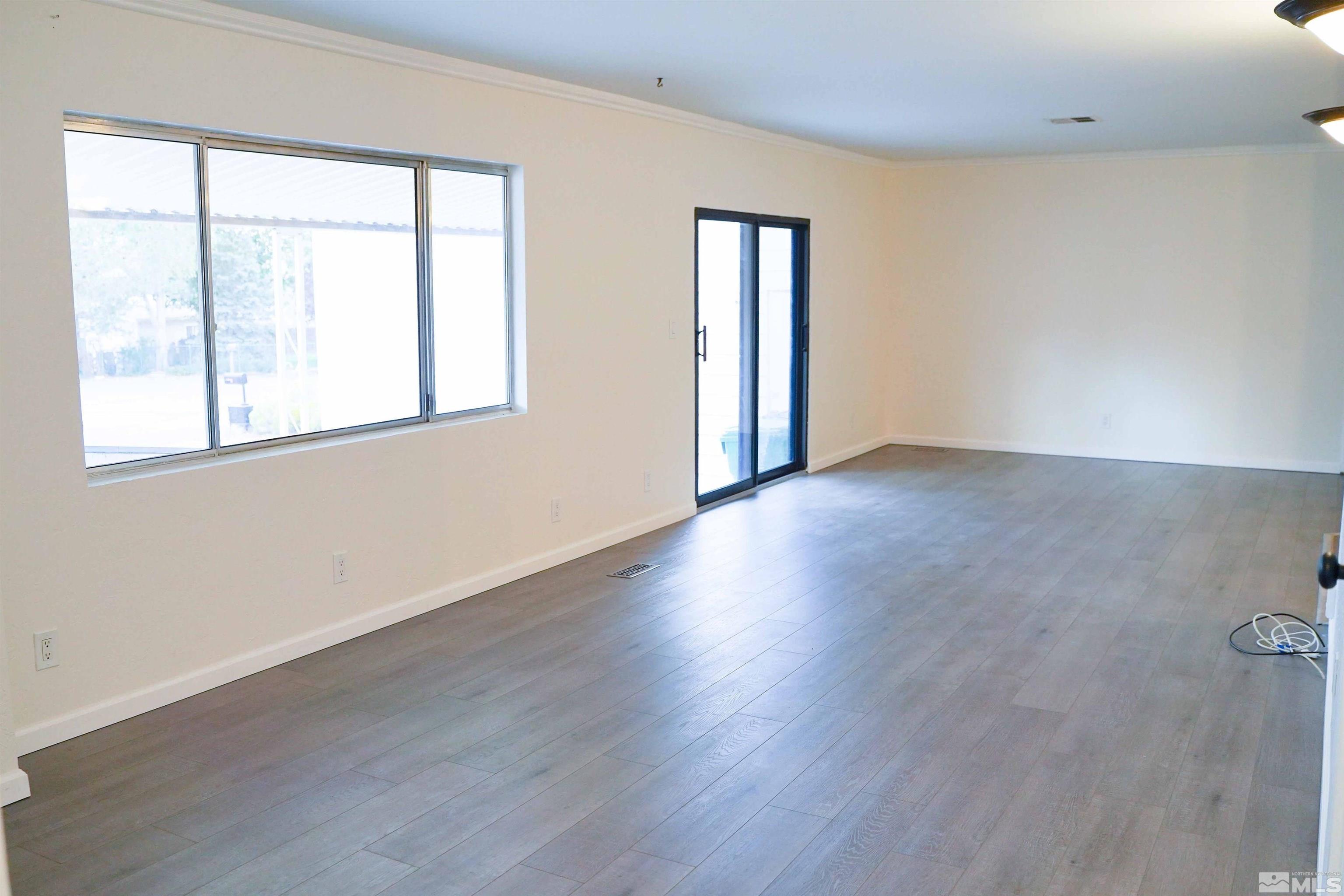 340 Saturn Circle Reno, NV 89521 - Photo 4 of 20 an empty room with wooden floor and windows
