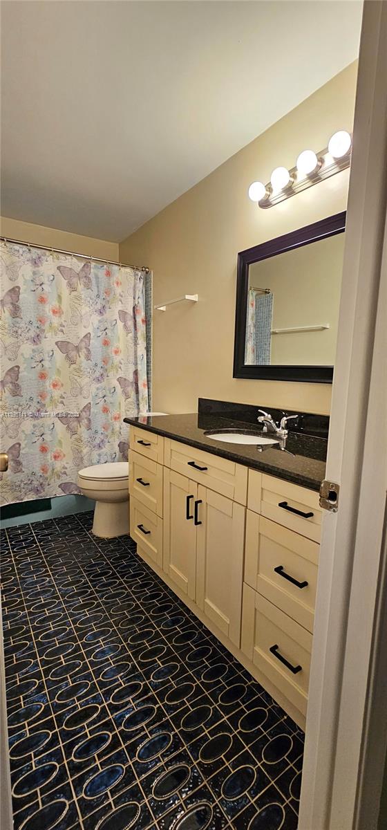 Lauderdale West Plantation Plantation, FL 33322 - Photo 7 of 17 a bathroom with a toilet a sink and a mirror