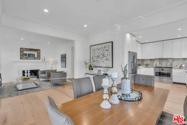 a living room with furniture kitchen view and a wooden floor