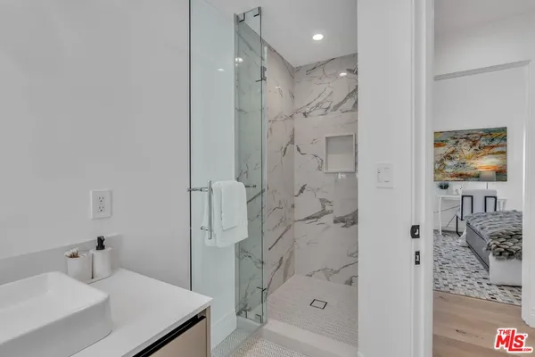 a bathroom with a shower sink and mirror