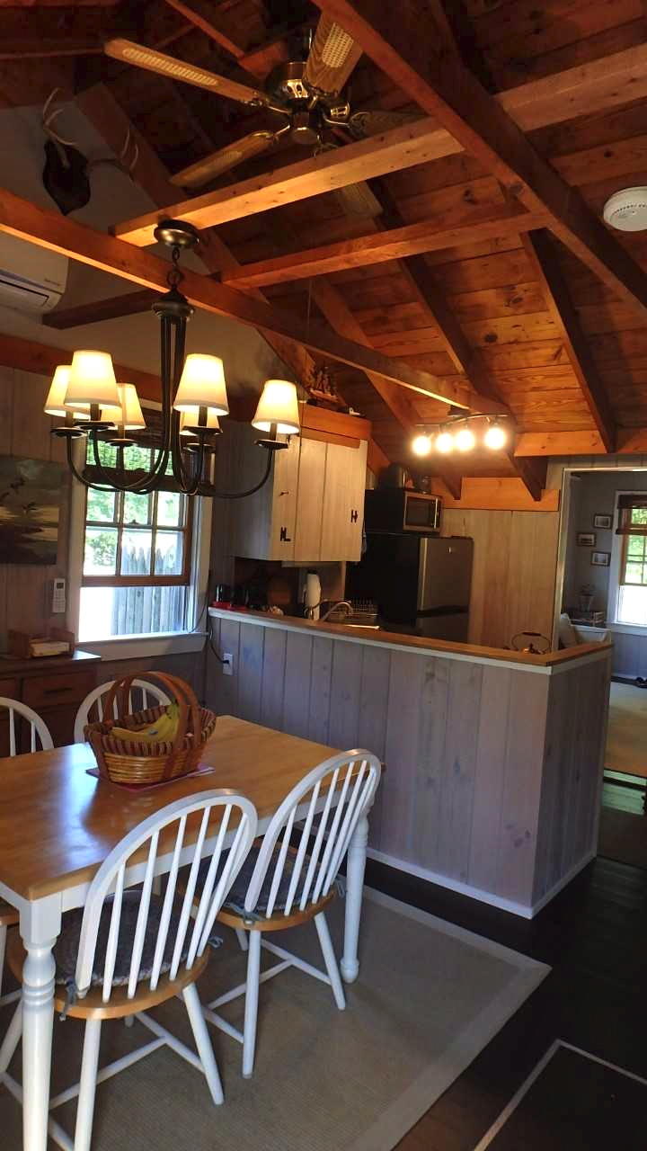 60 Designers Road, Unit C Wellfleet, MA 02667 - Photo 10 of 18 a dining room with furniture and a chandelier