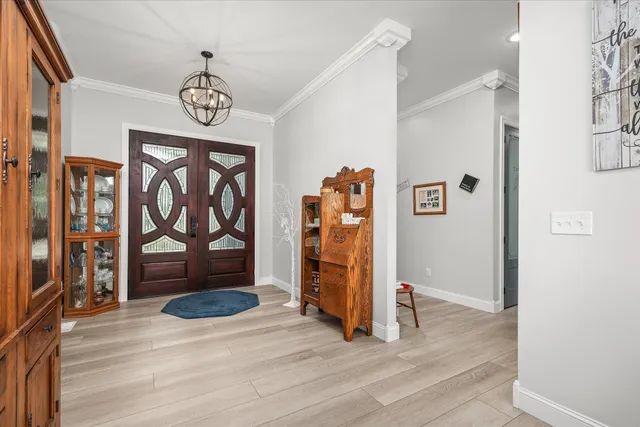 a living room with furniture kitchen view and a chandelier