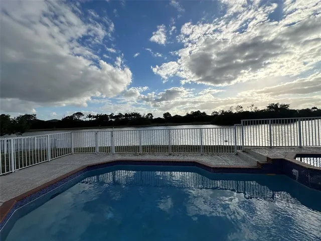a view of swimming pool with outdoor seating and plants