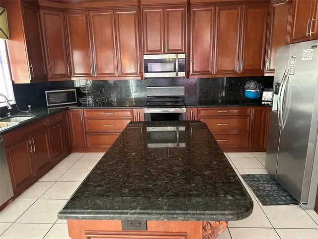 a kitchen with wooden cabinets a sink and a stove