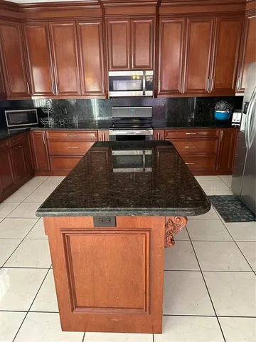 a kitchen with granite countertop a stove a sink and a microwave