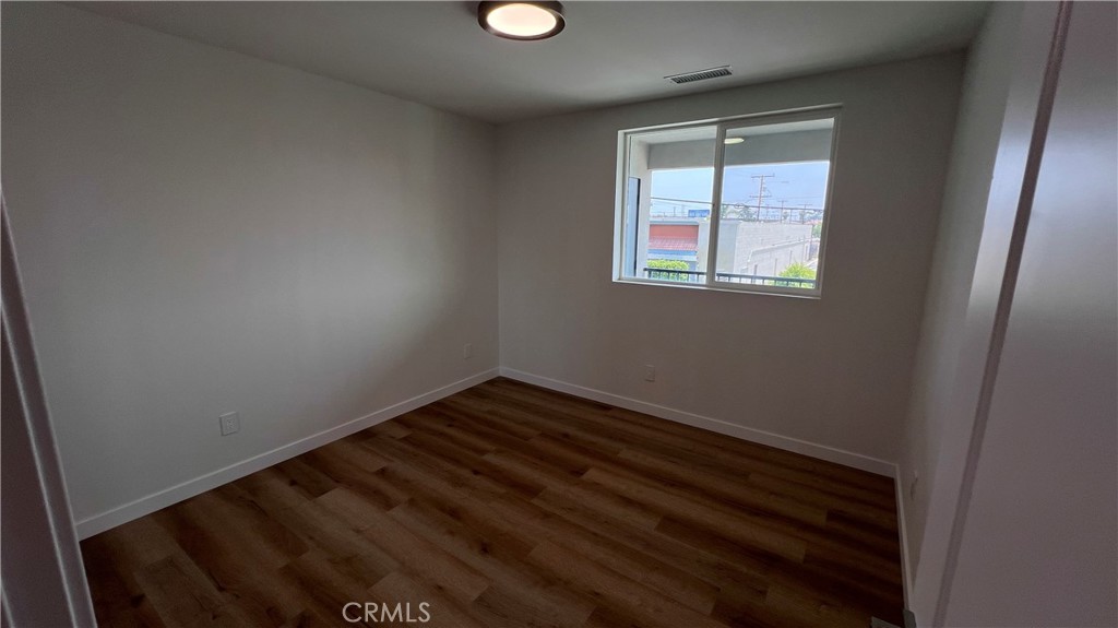 955 North Acacia Avenue, Unit B Compton, CA 90220 - Photo 11 of 15 a view of an empty room with wooden floor and a window