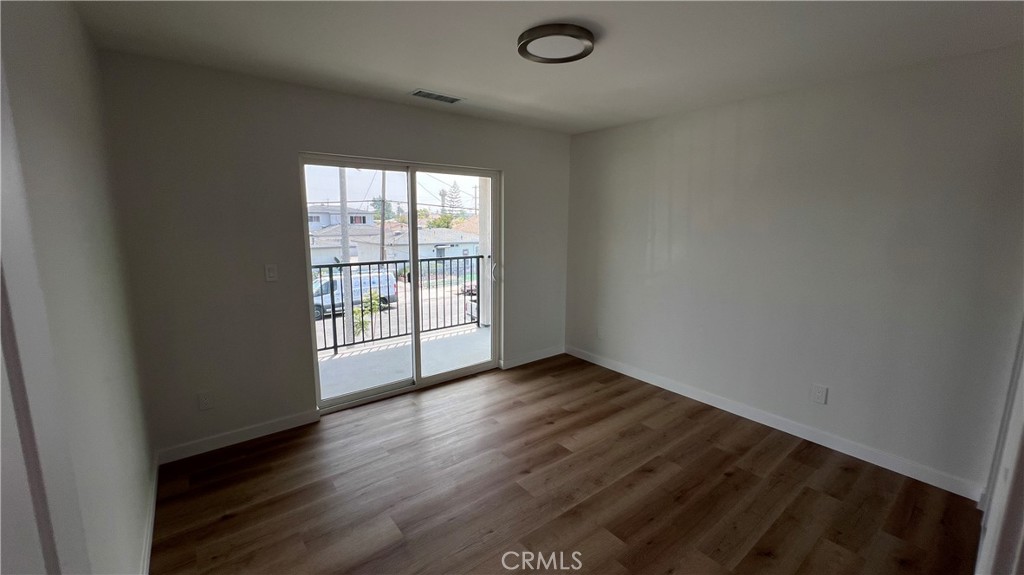 955 North Acacia Avenue, Unit B Compton, CA 90220 - Photo 12 of 15 an empty room with wooden floor and windows