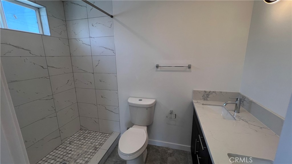 955 North Acacia Avenue, Unit B Compton, CA 90220 - Photo 9 of 15 a white toilet sitting next to a bathroom sink and a shower