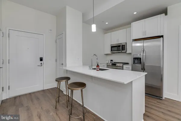 a kitchen with stainless steel appliances a sink a stove a refrigerator and cabinets