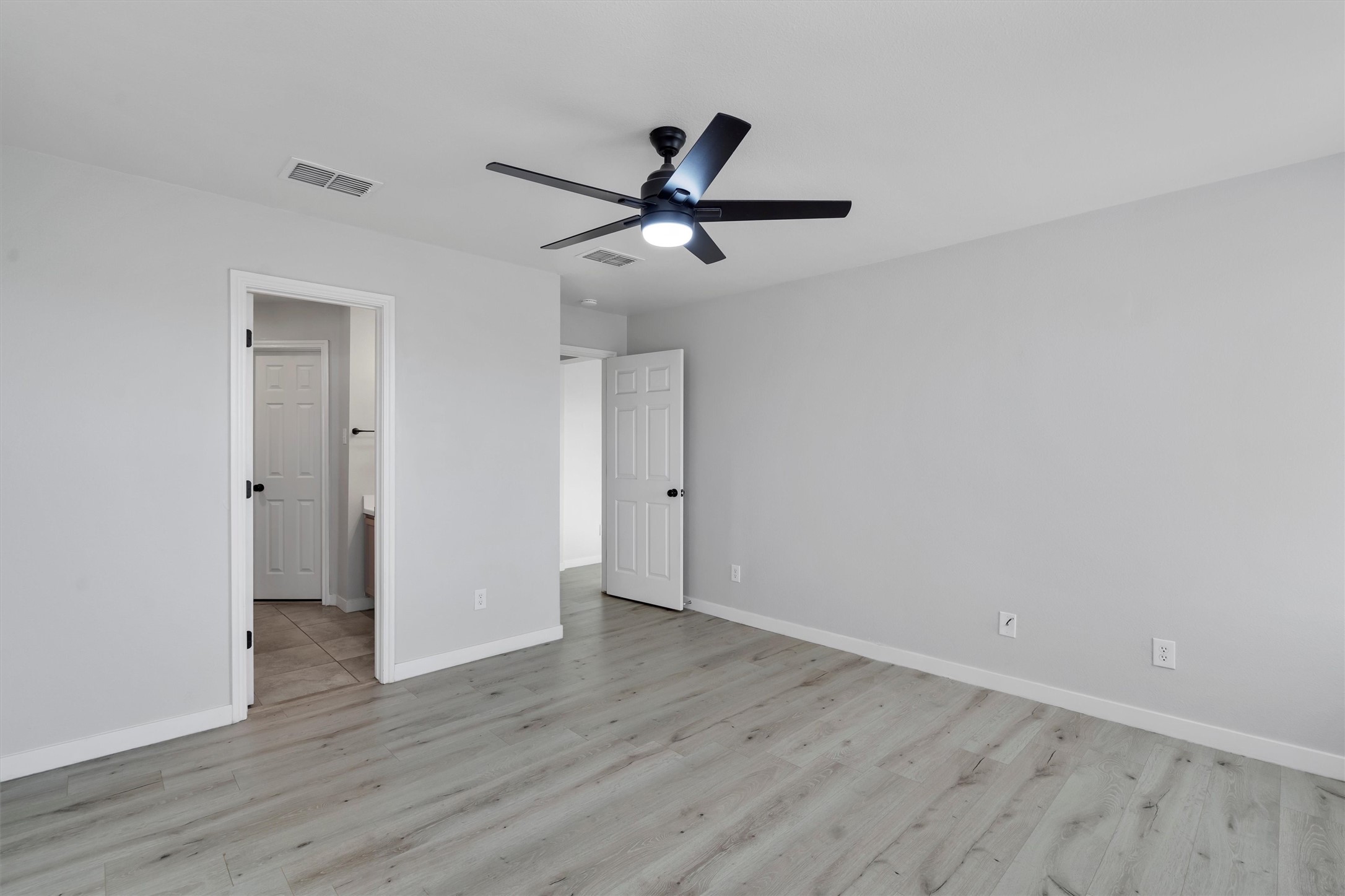 313 Drystone Trail Liberty Hill, TX 78642 - Photo 11 of 17 Unfurnished bedroom featuring ceiling fan and light wood-style flooring