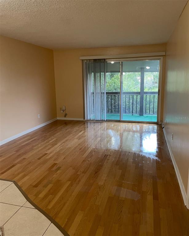 6306 Newtown Circle, Unit 6C5 Tampa, FL 33615 - Photo 13 of 24 a view of an empty room with wooden floor and a window