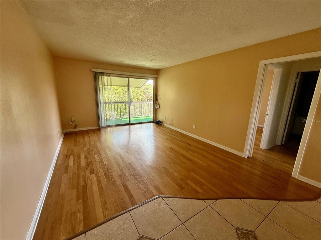 6306 Newtown Circle, Unit 6C5 Tampa, FL 33615 - Photo 14 of 24 a view of an empty room with wooden floor and a window