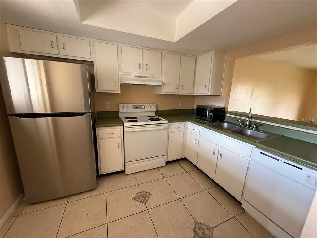 6306 Newtown Circle, Unit 6C5 Tampa, FL 33615 - Photo 10 of 24 a kitchen with a refrigerator a sink and cabinets