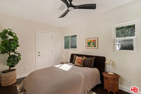 a bedroom with a bed and a potted plant