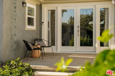 a backyard of a house with barbeque oven table and chairs