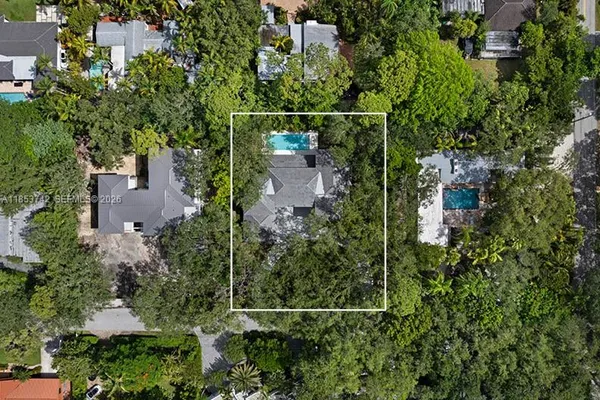 an aerial view of a house with a yard and large trees