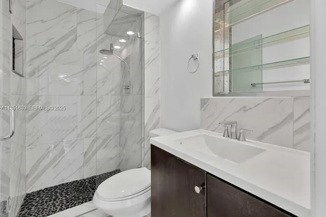 a bathroom with a sink a toilet and shower