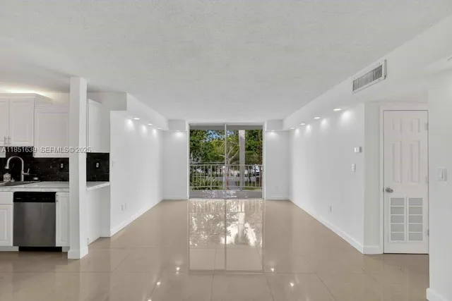 a view of a big room with windows and kitchen view