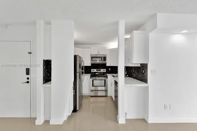 a kitchen with stainless steel appliances and white cabinets