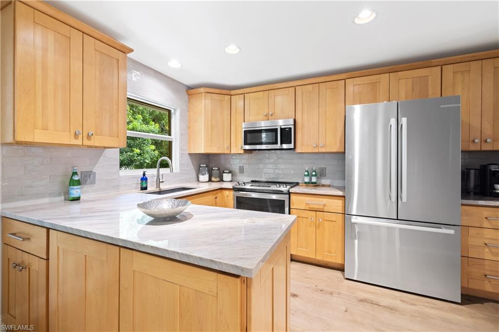 a kitchen with refrigerator a microwave a sink and cabinets